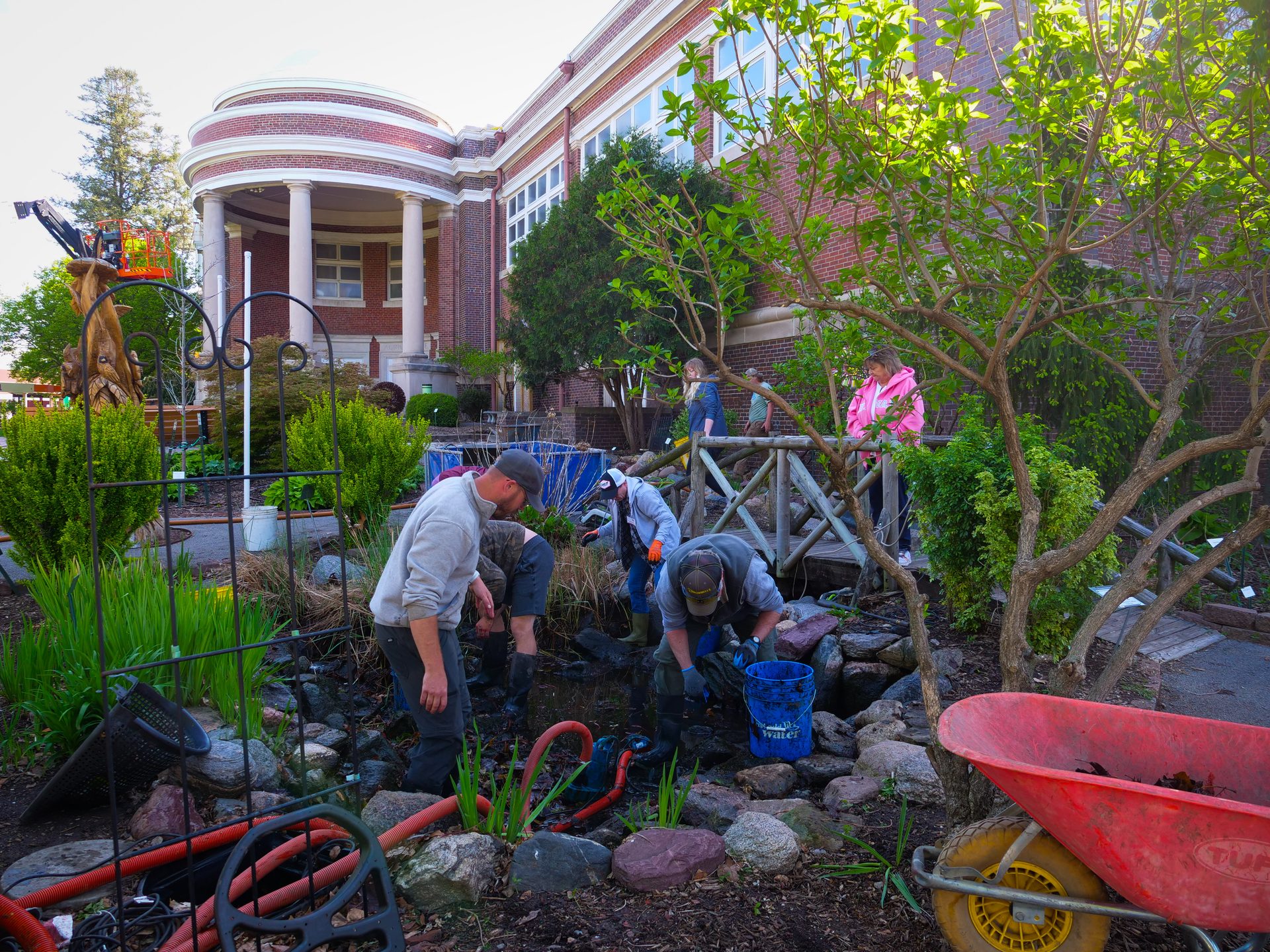 Crew draining and cleaning a garden pond during a spring service visit